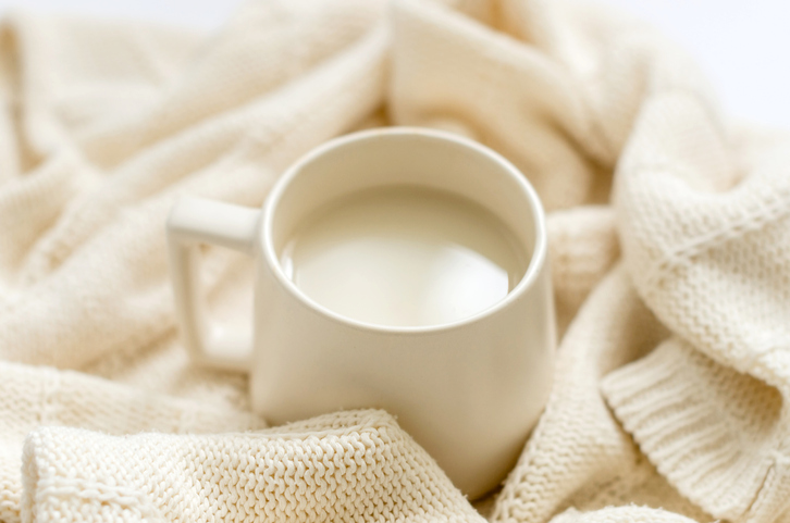 kop warme melk op een witte deken