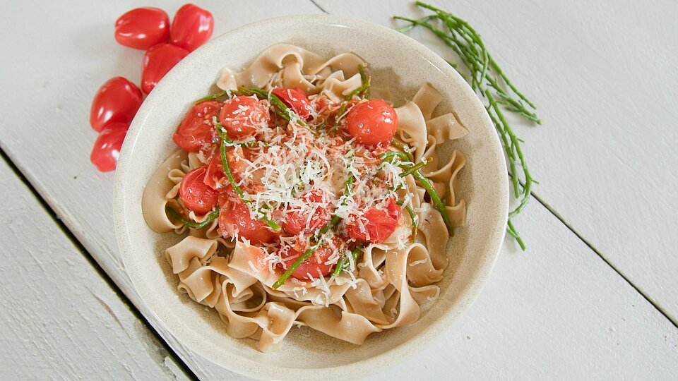 Bord pasta met tomaat en zeekraal