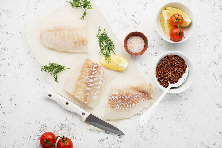 3 stukjes ongebakken kabeljauwfilet met daarbij kruiden, tomaat en citroen