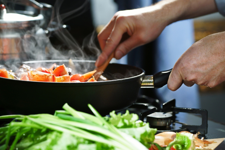 pan met groenten waarin geroerd wordt