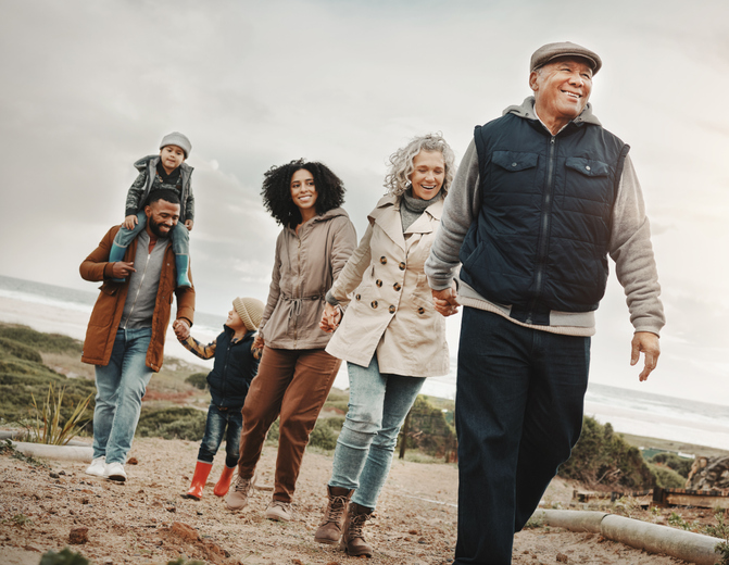 familie van jong tot oud aan het wandelen samen in duinen in de winter