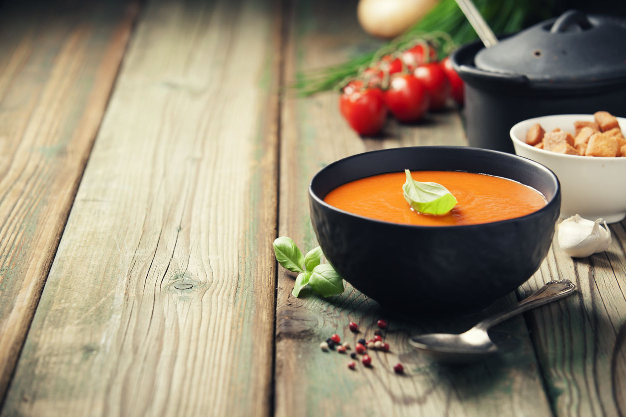 Tomaten sinaasappelsoep in een kom op tafel
