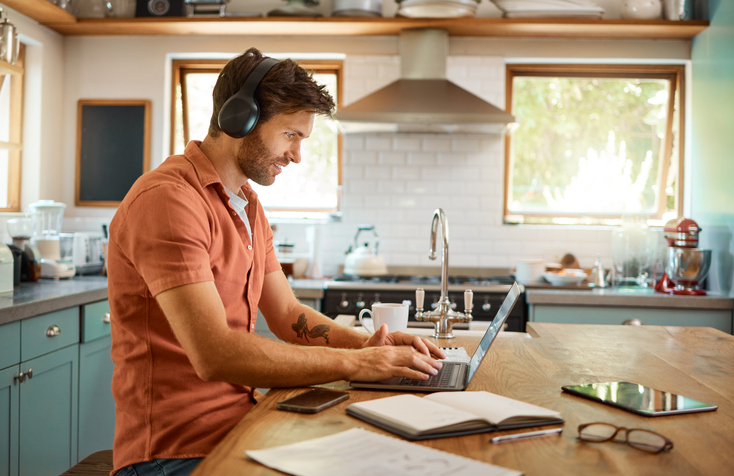 Man werkend op de laptop in de keuken
