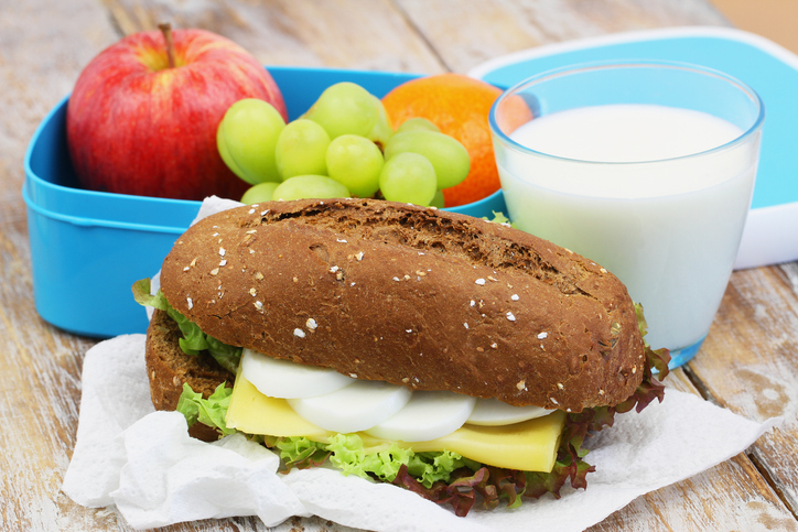 lunch van volkoren pistolet met beleg fruit en een glas melk