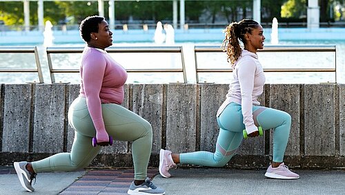 2 vrouwen die buiten lunges doen