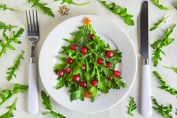 kerstboom van rucola op een wit bord