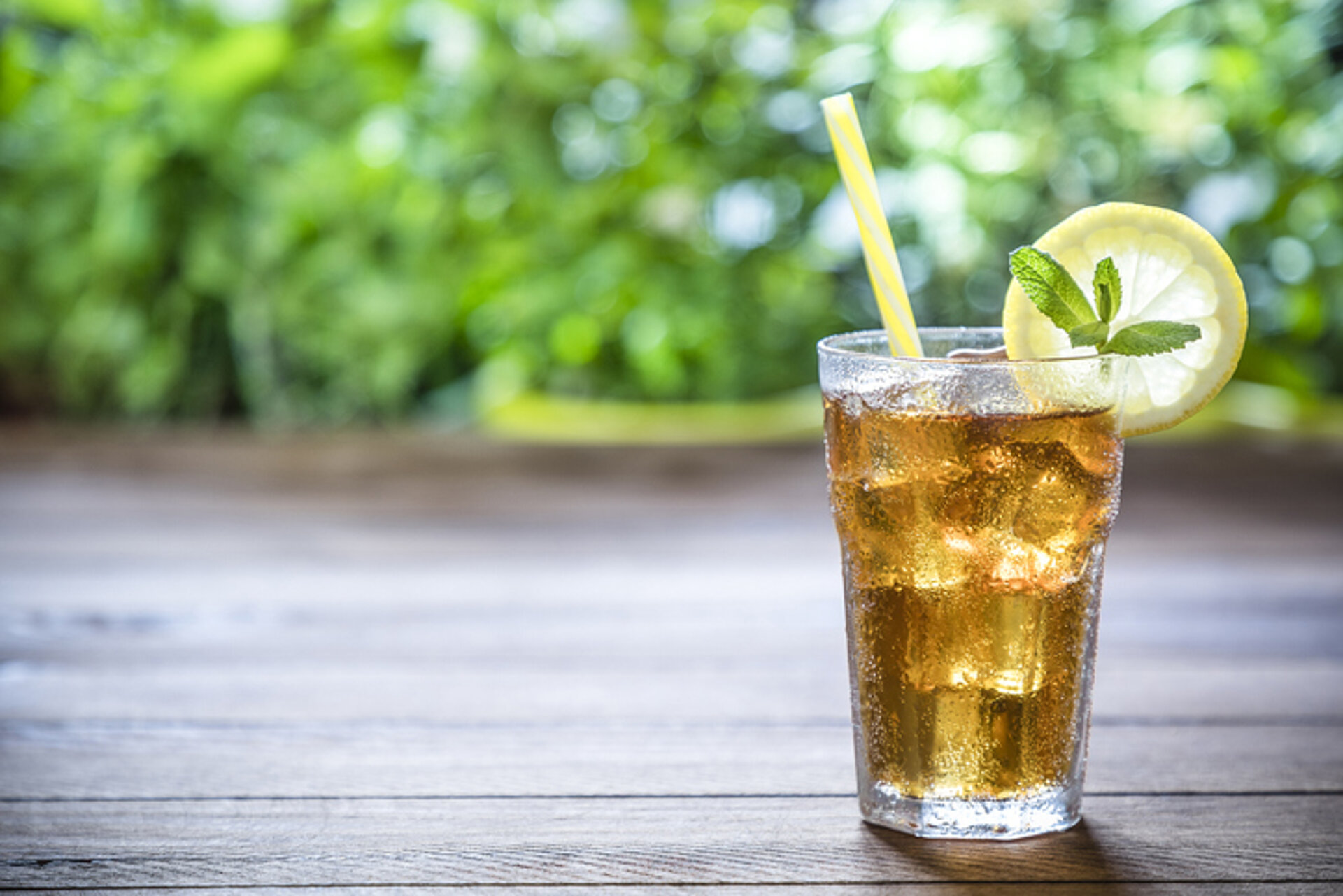 Glas ijsthee met ijsklontjes en citroen