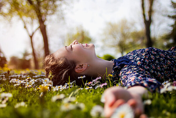vrouw in gras met bloemetjes