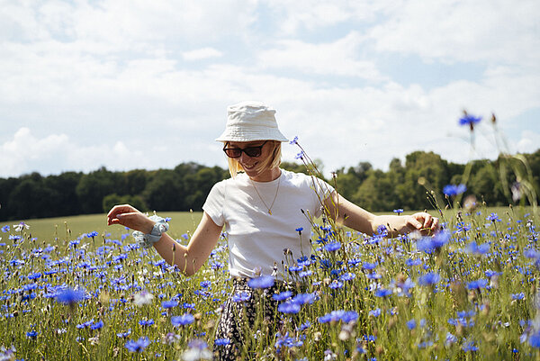 Ontspannen vrouw in een veld korenbloemen
