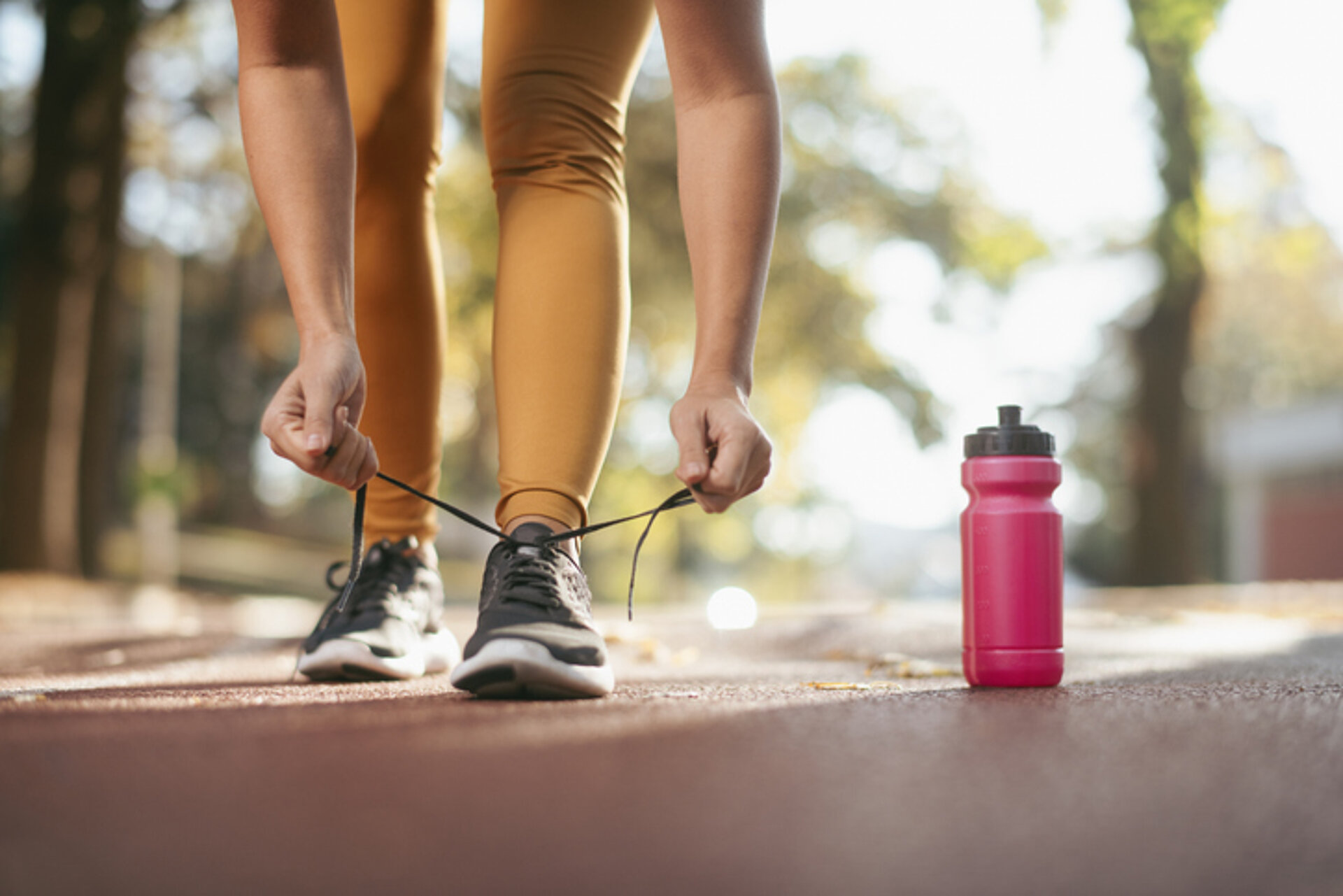 10 variaties voor de bidon bidon bij een vrouw die haar sportschoenen strikt