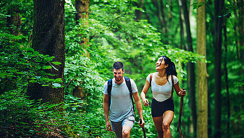 1325603504 Man en vrouw wandelen in het bos