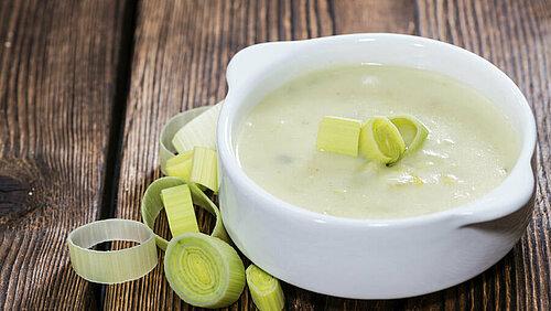 kom soep aardappel-prei met enkele ringen prei ernaast