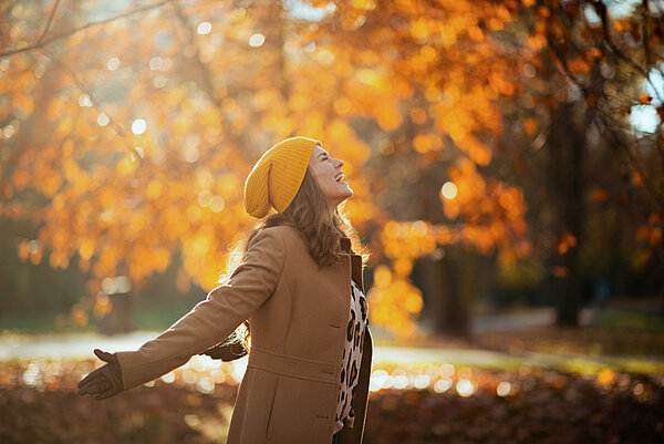 vrouw in herfstbos die inademt