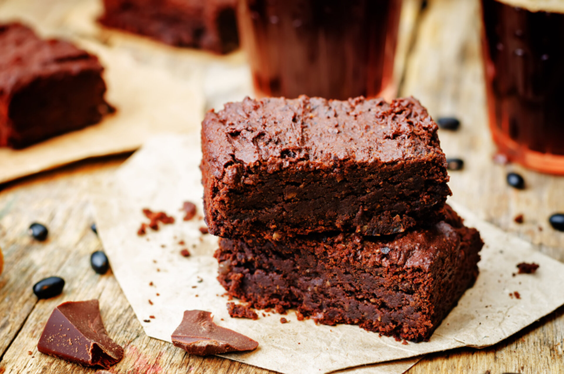 Blokje bruine brownie op een wit papiertje met snippers chocolade ernaast