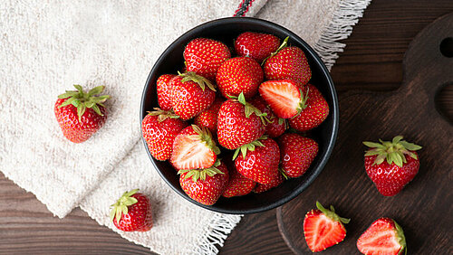 Aardbeien in een schaaltje op wit tafelkleed