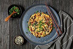 Bord met een met groenten gevulde pannenkoek op een donkeler Japans uitziende) tafel