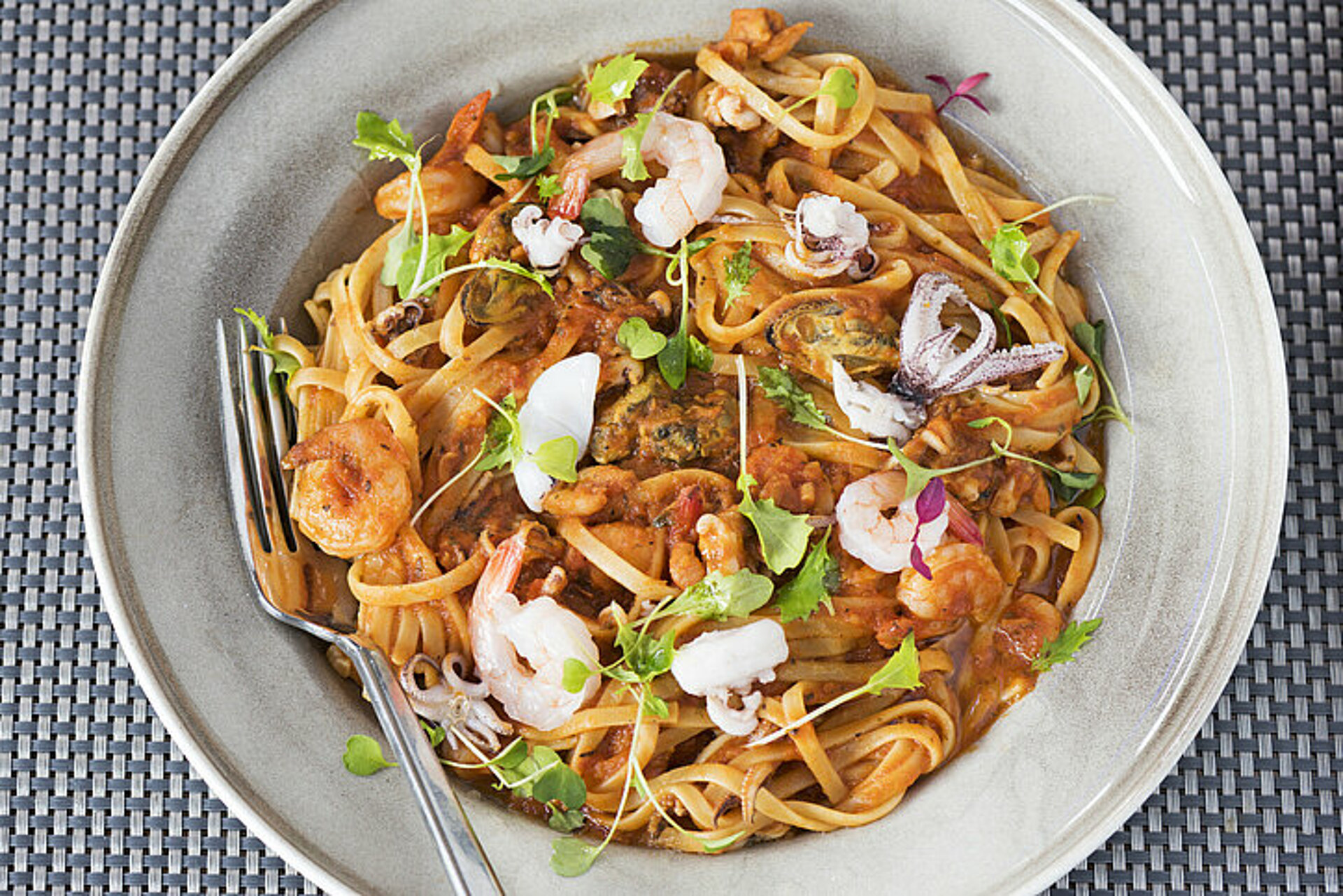 Goed gevulde tomaten-vissaus Bord pasta met rode saus en garnalen