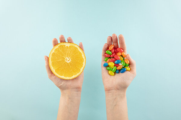 2 handen 1 met fruit andere met snoepjes