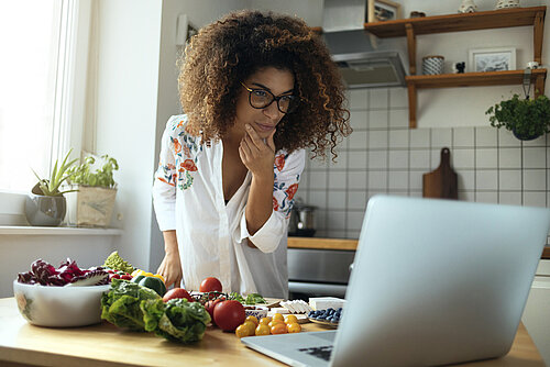 Vrouw achter een laptop recepten zoeken
