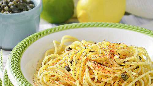 Vol bord spaghetti met citroen op de achtergrond