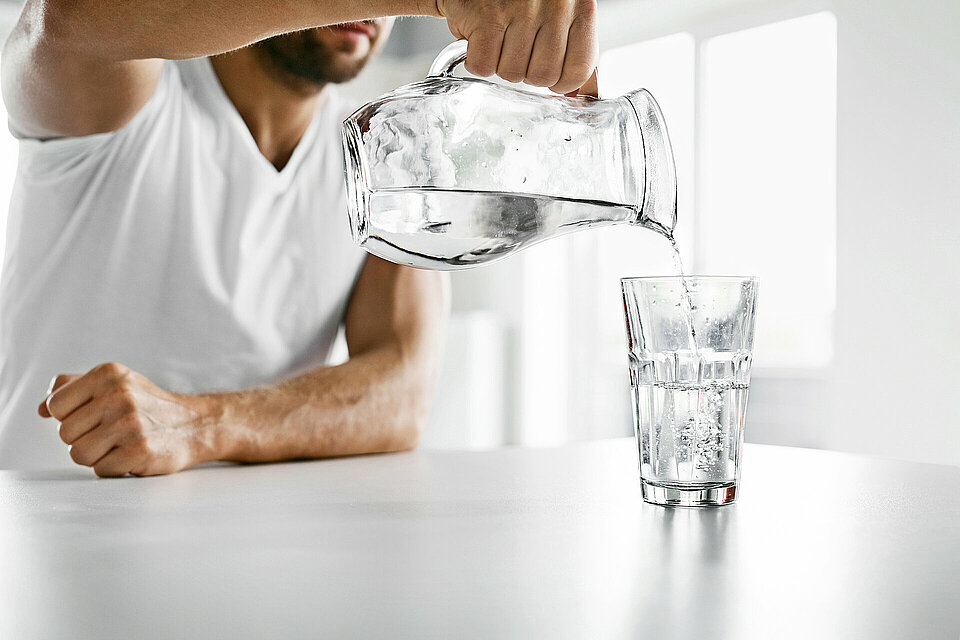 man schenkt water in