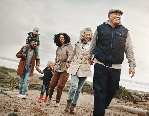 familie van jong tot oud aan het wandelen samen in duinen in de winter