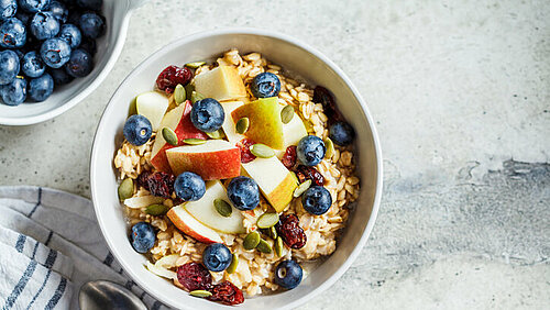 kom met Bircher-muesli, blauwe bessen, appel en cranberries