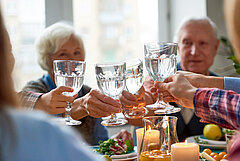 Eters heffen het waterglas tijdens de maaltijd 