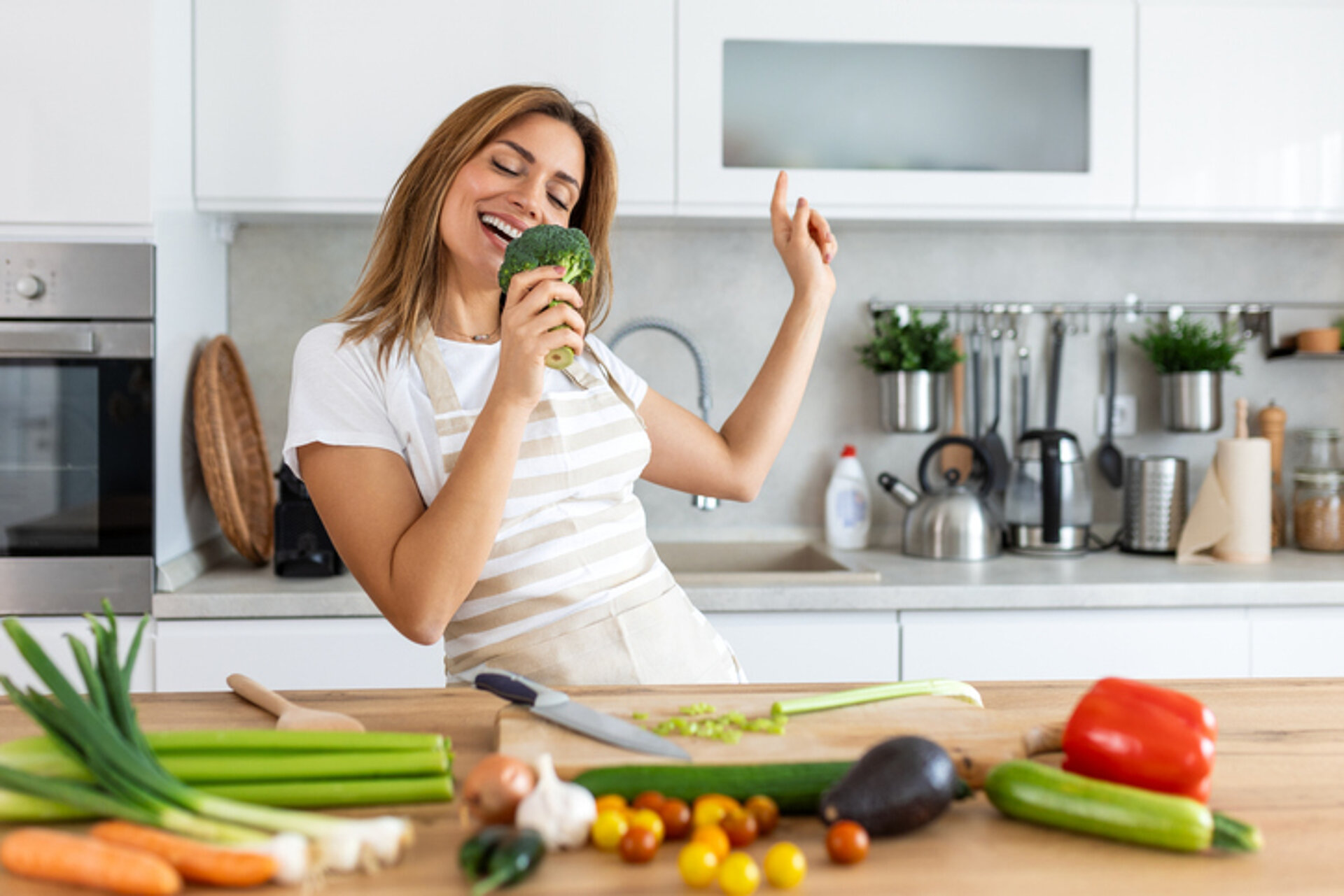 Waarom muziek blij maakt vrouw zingt in de keuken
