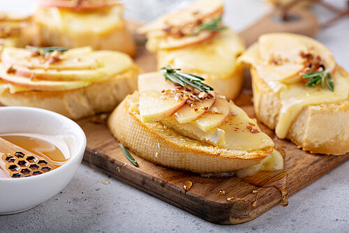 Geroosterde sneetjes brood met brie gesmolten en plakjes peer