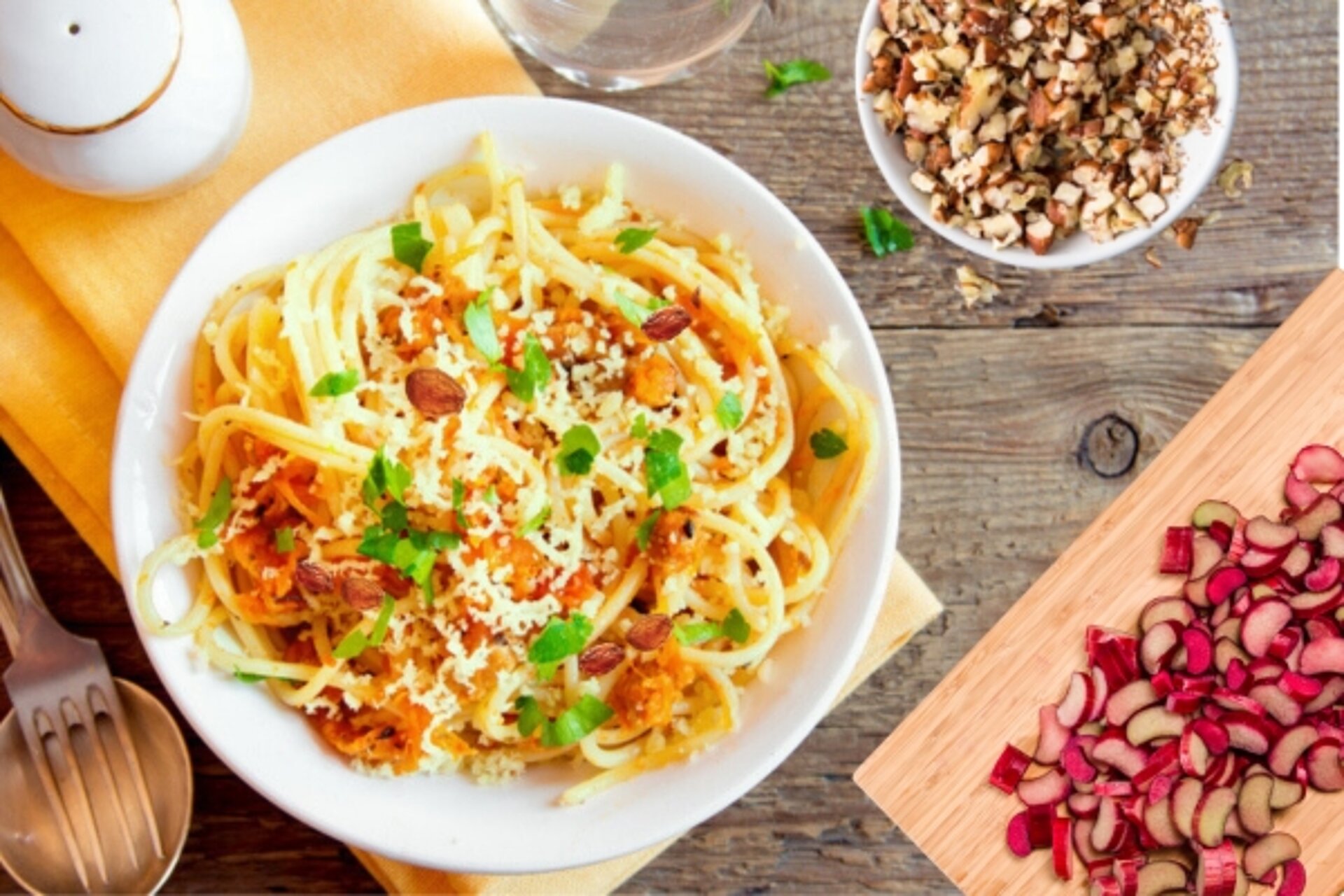 bord met pasta daarbij rabare ren een schaaltje noten