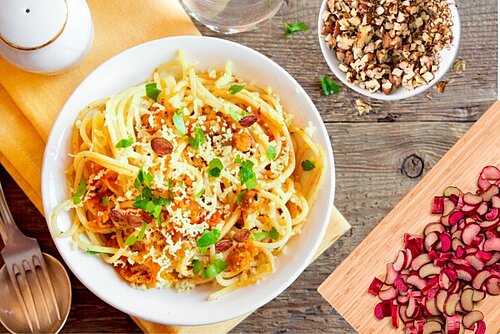 bord met pasta daarbij rabare ren een schaaltje noten